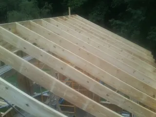 New roof rafters set over an addition before sheathing in Romney