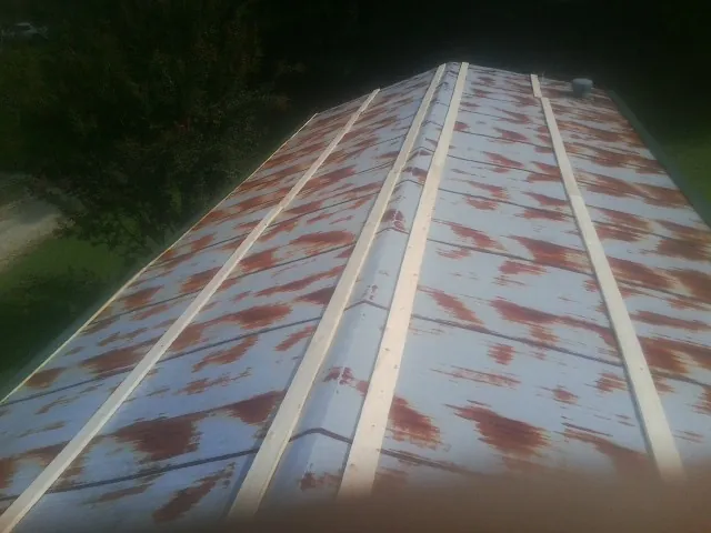 Rusted metal roof panels with new wood purlins before replacement — Storm Damage Roof Repair in Romney by Roofing Brothers